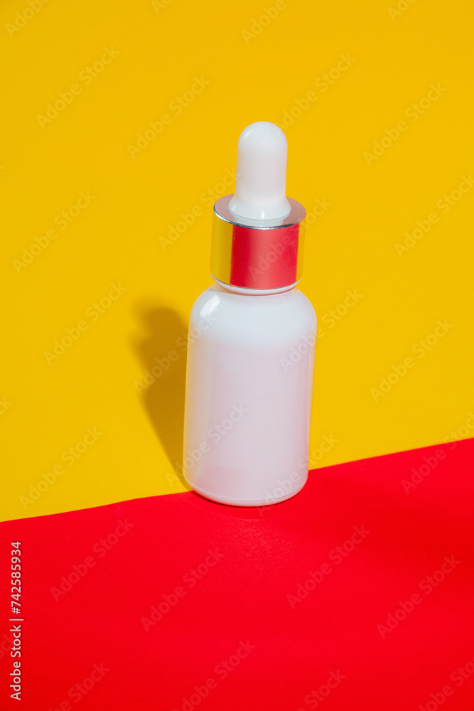 Plastic white tube for cream or lotion. Skin care or sunscreen cosmetic on yellow and red background Plastic white tube for cream or lotion. Skin care or sunscreen cosmetic on yellow and red background
