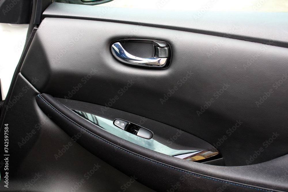 Electric Car door trim with windows control. Car Inside Door Handle Interior. Leather Door trim. Front door trim of a Electric car. Electric Car interior.