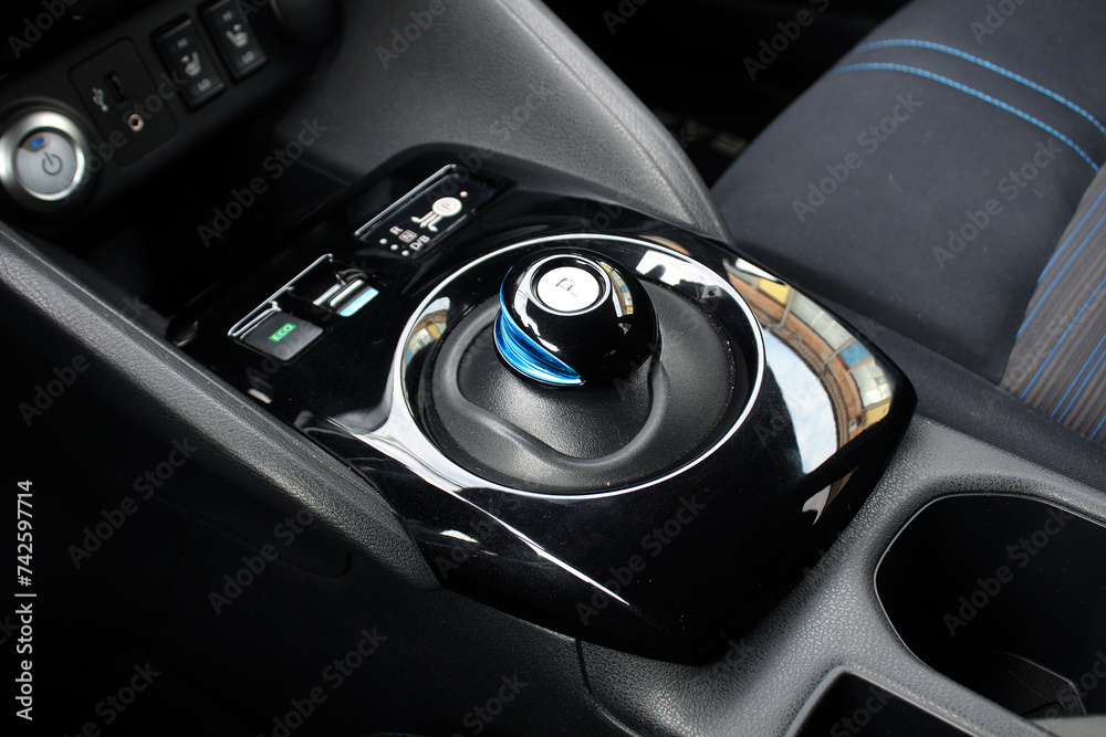Close up Automatic gear stick of a modern electric car. Modern car interior details. Car detailing. Automatic transmission lever shift. Close up Automatic gear stick of a modern electric car. Modern car interior details. Car detailing. Automatic transmission lever shift.
