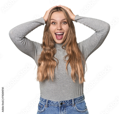 Studio portrait of a blonde Caucasian woman screaming, very excited, passionate, satisfied with something. © Asier