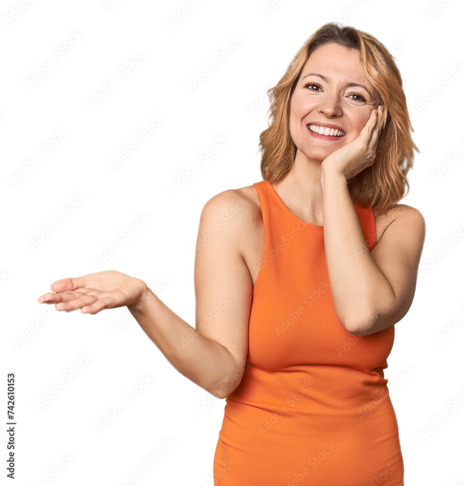 Blonde middle-aged Caucasian woman in studio holds copy space on a palm, keep hand over cheek. Amazed and delighted. Blonde middle-aged Caucasian woman in studio holds copy space on a palm, keep hand over cheek. Amazed and delighted.