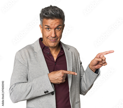 Cuadro en lienzo Middle-aged Latino man shocked pointing with index fingers to a copy space