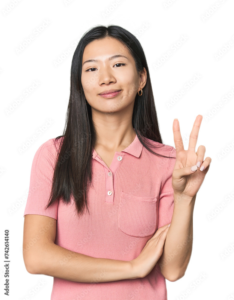 Young Chinese woman in studio setting showing number two with fingers. Young Chinese woman in studio setting showing number two with fingers.
