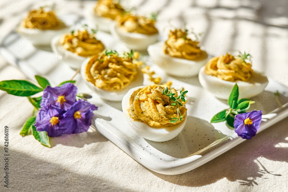 Easter breakfast idea. Stuffed easter eggs mimosa with egg yolk, turmeric, cream cheese and cress salad. Happy Easter traditional dish concept.