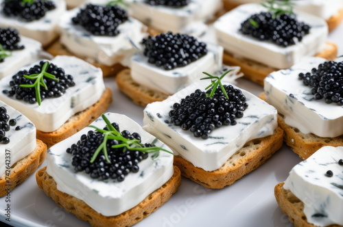 Crackers with Cream Cheese and Black Caviar Garnished