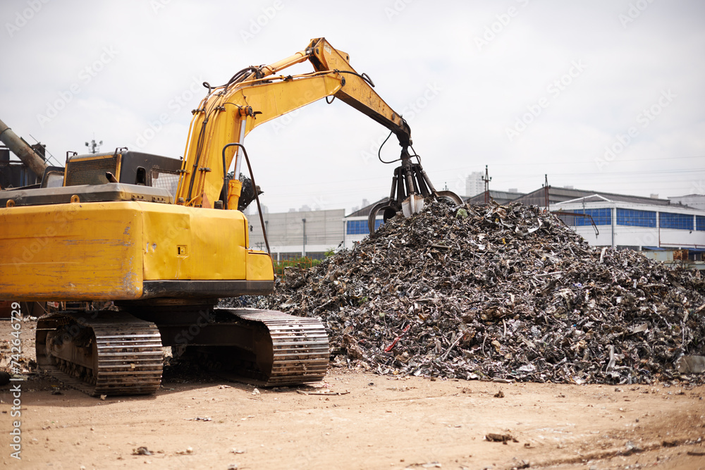 Obraz premium Crane, machine and scrapyard to recycle metal for sustainability, manufacturing or stop pollution. Vehicle, tractor and outdoor in junkyard, plant or ecology for iron, steel industry and environment