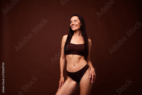 No filter photo of stunning dreamy girl sportive shape thin waist belly hips wear stylish lingerie isolated on brown color background © deagreez