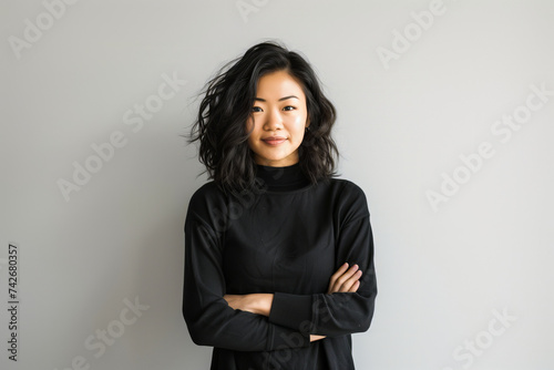 Professional Asian Businesswoman Posing Confidently with Arms Crossed in a Minimalist Office Setting, Exuding Leadership and Confidence © Alienmonster Images