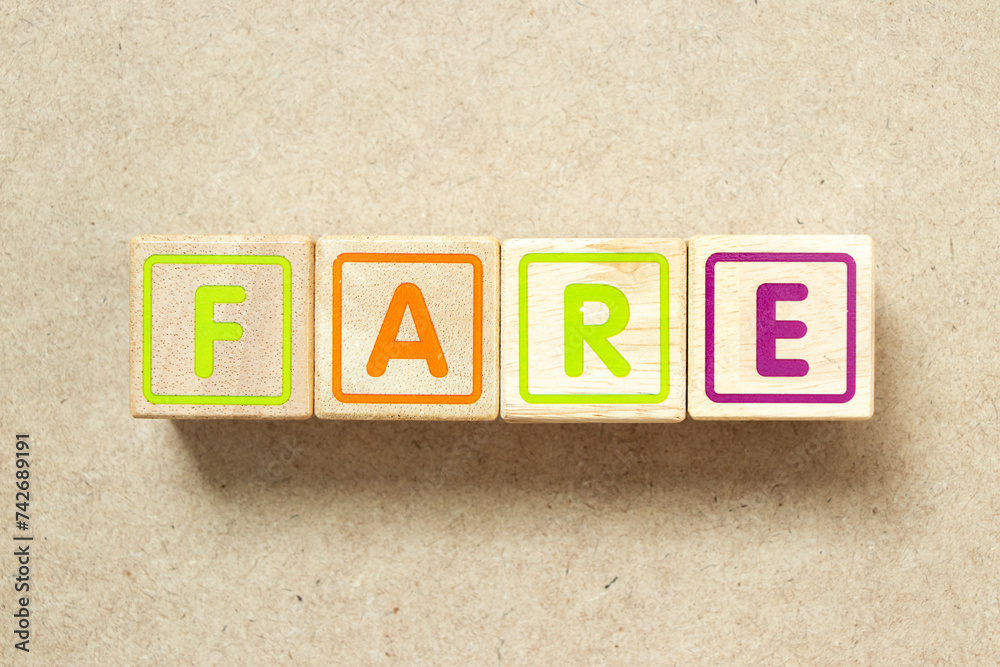 Wooden alphabet letter block in word fare on wood background Wooden alphabet letter block in word fare on wood background