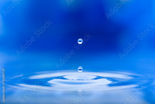 a drop of water jumps upwards from the water surface