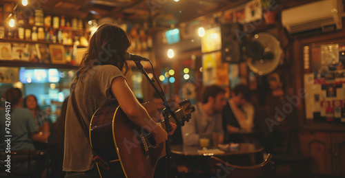 Musician serenades a captivated crowd with an acoustic guitar performance in the ambient lighting of a bustling bar.