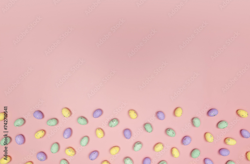 Top view of colourful easter eggs on pink background. Creative easter composition, spring, copy space, flat lay.