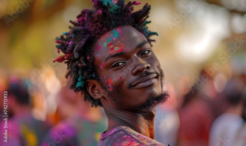 Dark-skinned guy with a fashionable hairstyle at the festival of colors