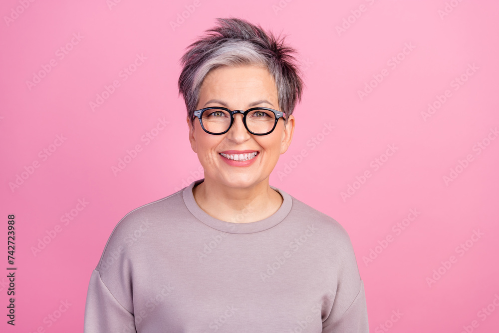 Portrait of pensioner old businesswoman in violet sweatshirt smiling good mood realtor specialist isolated on pink color background