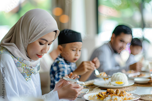 Thai Muslim family in white modern dining room eating depth of field blur background photo