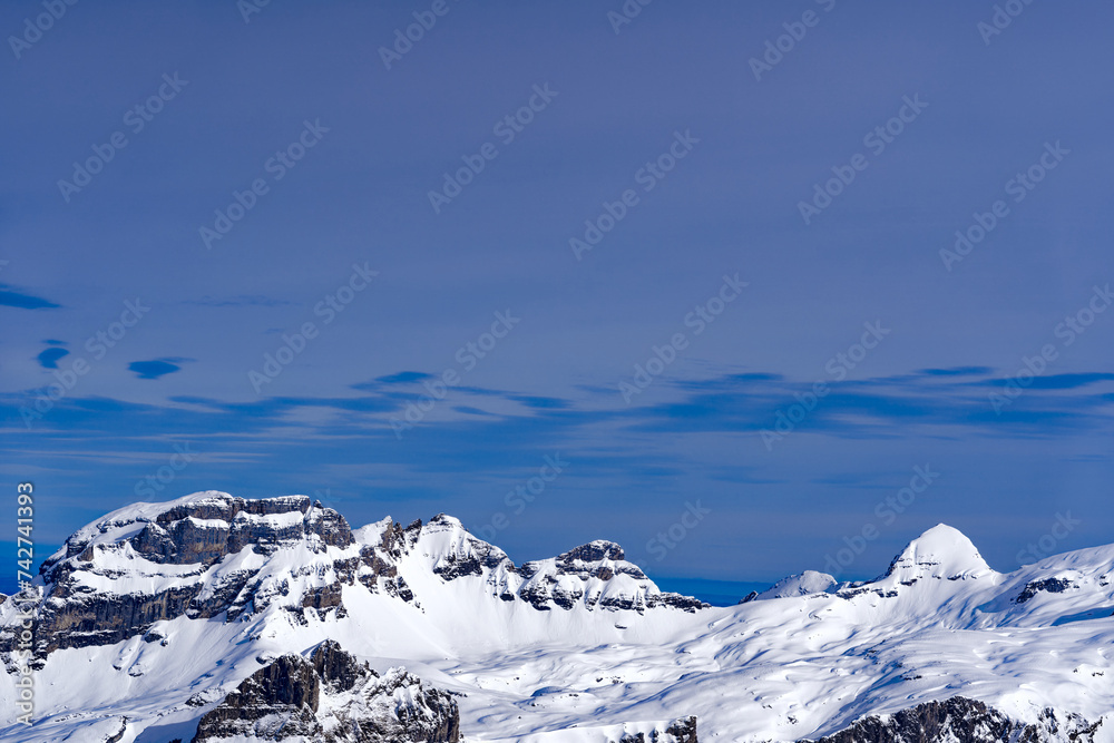 Scenic view of mountain panorama with snow covered mountain peaks in the Swiss Alps at mount Titlis on a sunny winter day. Photo taken February 21st, 2024, Titlis, Engelberg, Switzerland. Scenic view of mountain panorama with snow covered mountain peaks in the Swiss Alps at mount Titlis on a sunny winter day. Photo taken February 21st, 2024, Titlis, Engelberg, Switzerland.