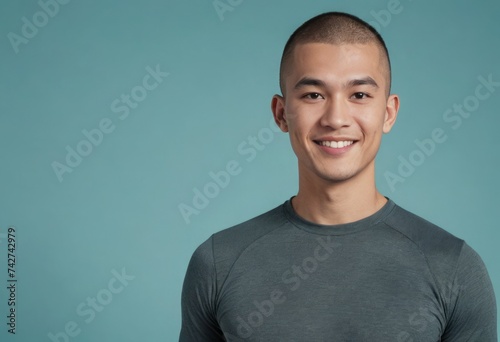 A man with a buzz cut and a confident smile wears a grey tee, presenting a look of casual ease and simplicity. photo