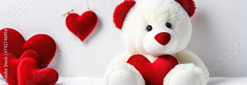 A teddy bear with a red heart on a white textured blanket, symbolizing love and affection, suitable for Valentine's Day concepts photo