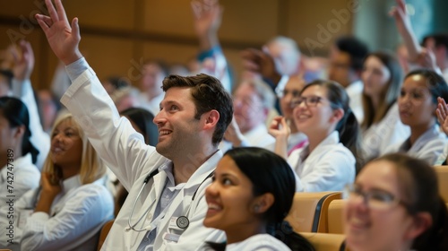 an audience of culturally diverse dentists in a lecture hall with one white dentist raising his hand