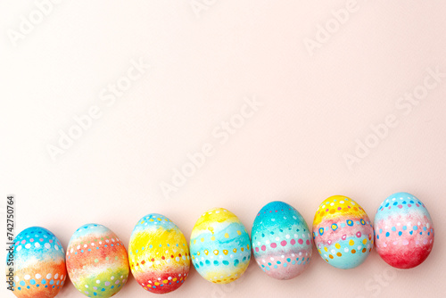 Easter background. Handmade painted eggs lie on a pink background.