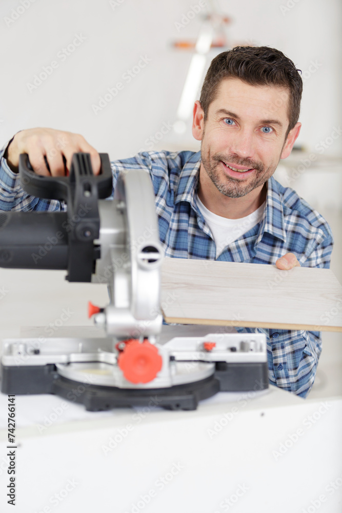 adult master sawing a platband with a circular saw indoors adult master sawing a platband with a circular saw indoors