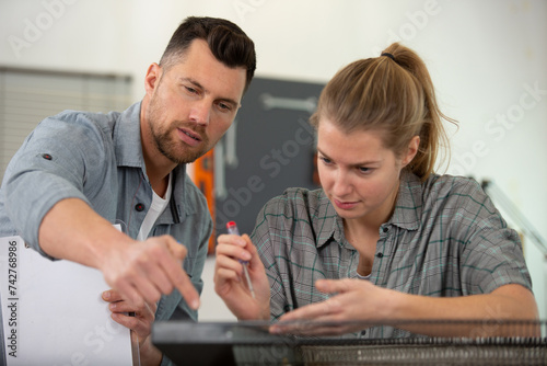 portrait of workers fixing a tv in the workshop photo