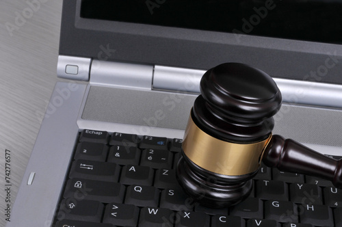 Concept de justice avec un marteau de juge sur un clavier d'ordinateur portable en gros plan photo
