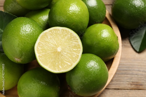 Whole and cut fresh limes on table, closeup