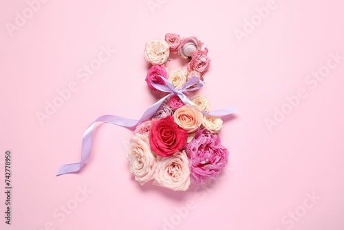 8 March greeting card design made with beautiful flowers on pink background, top view