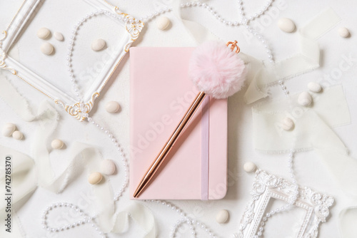 Tableau sur toile Pink notebook, decorative fur pen and romantic decor on white close up, textbook