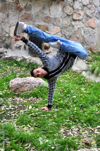 A young acrobatic dancer dances in nature