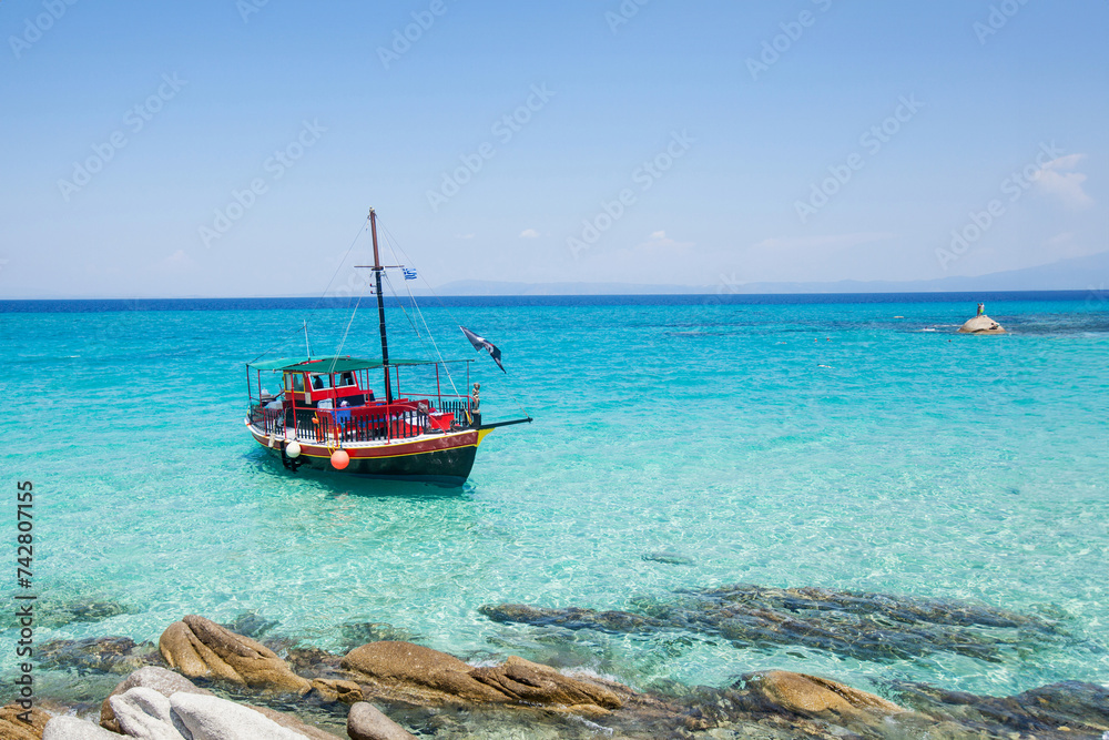 Fototapeta premium Relaxing summer cruise on a blue sea, tourist boat. Perfect vacation for nature-loving tourists seeking leisure and adventure.