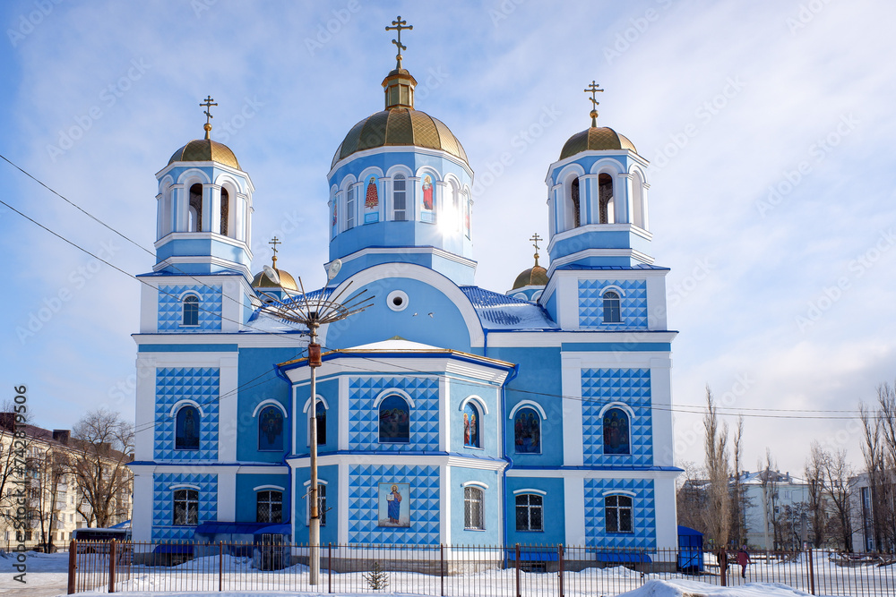 Orthodox church in the forest in winter against the background of a blue sky in sunny weather