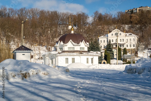 Orthodox church in the forest in winter against the background of a blue sky in sunny weather