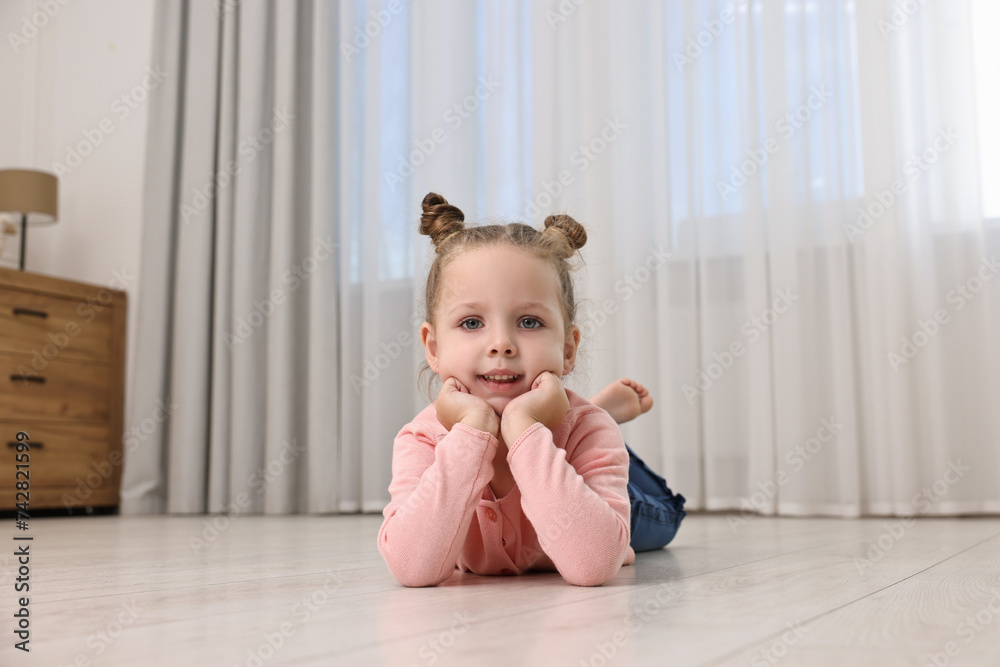 Cute little girl lying on warm floor at home. Heating system Cute little girl lying on warm floor at home. Heating system