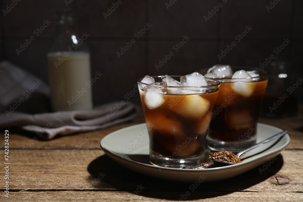 Refreshing iced coffee in glasses, ingredients and spoon on wooden table Refreshing iced coffee in glasses, ingredients and spoon on wooden table