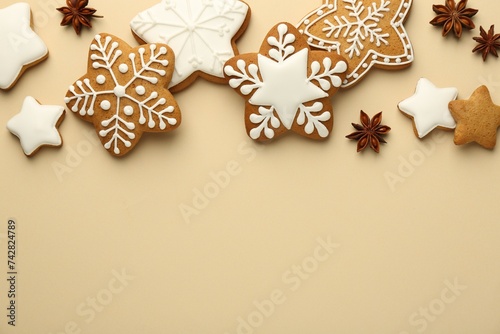 Tasty Christmas cookies with icing and anise stars on beige background, flat lay. Space for text