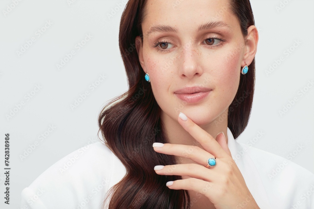 Close up portrait of a beautiful elegant woman with freckles with stylish jewelry on a white background. Beautiful girl with jewelry. Close up portrait of a beautiful elegant woman with freckles with stylish jewelry on a white background. Beautiful girl with jewelry.