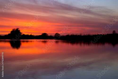 Clouds and trees are reflected in the lake in fantastic colors © tiger2506