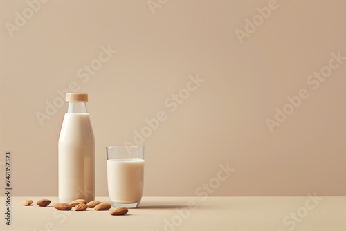 Almond milk in a bottle with glass and almonds on beige background  symbolizing health and wellness.
