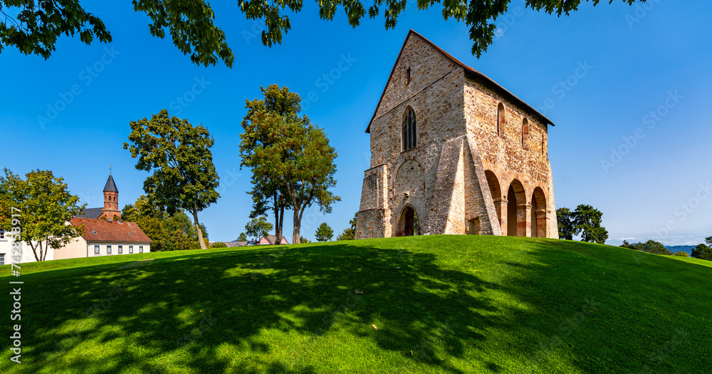 Lorsch Abbey with King’s Hall and Monastery Mound near Worms in Hessen Germany is public historical monument from the Carolingian Empire on a summer day. Panorama form wide angle frog perspective.