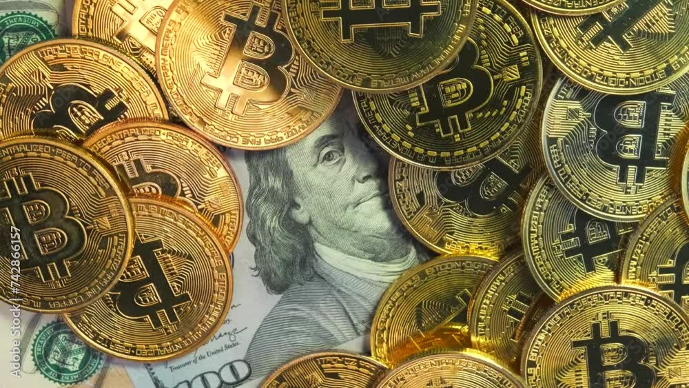 Golden shiny bitcoin crypto currency coins on US 100 dollar bills rotate close up. Virtual money coin and American dollar cash. 