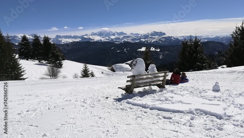bonhommes de neige assis sur un banc qui contemplent le Mont Blanc en hiver