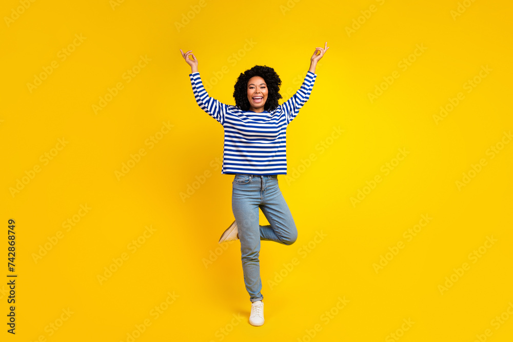 Full length photo of cheerful glad girl wearing trendy sailor outfit hold empty space isolated yellow color background Full length photo of cheerful glad girl wearing trendy sailor outfit hold empty space isolated yellow color background