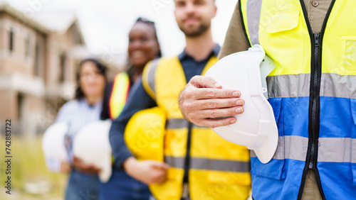 Foto Close up shot of engineer or foreman team holding a protective safety helmet beside their body