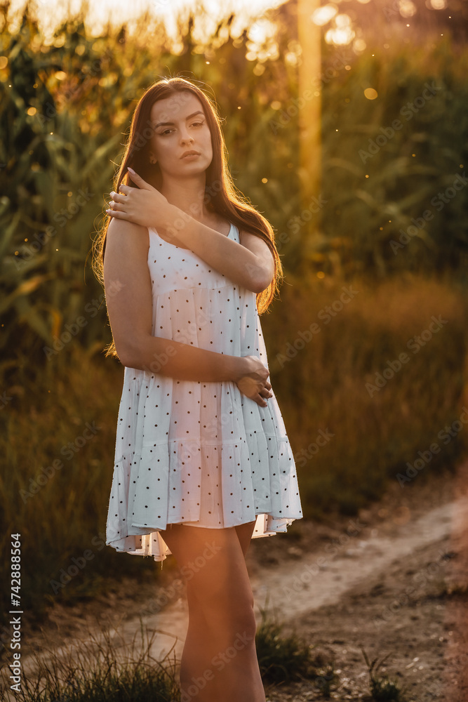 Young beautiful woman in white dress in corn field. Young beautiful woman in white dress in corn field.