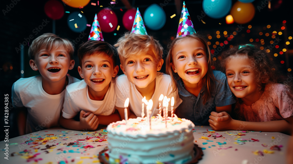 Group of adorable kids looking at birthday cake with candles