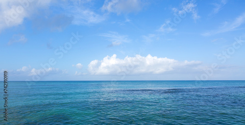 Tropical paradise beach with white clouds and blue caribbean sea.