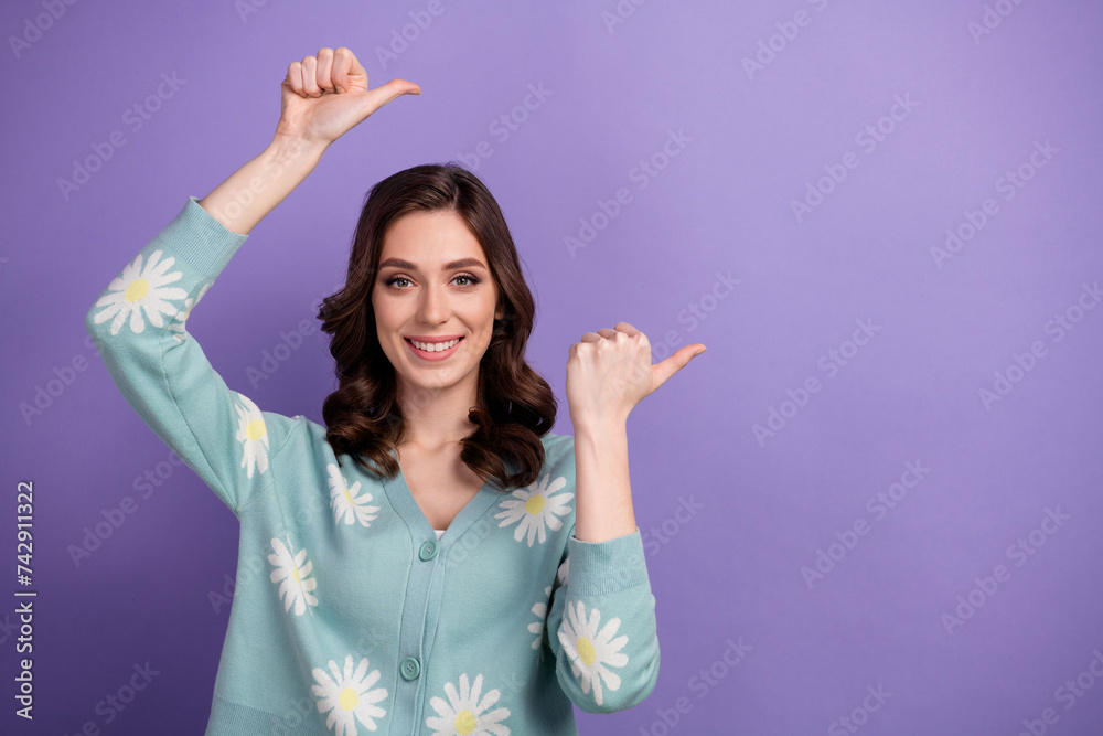 Photo of adorable positive lady dressed flower print cardigan showing two thumbs empty space isolated violet color background Photo of adorable positive lady dressed flower print cardigan showing two thumbs empty space isolated violet color background
