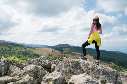 Woman standing in the summer mountain with stunning view 